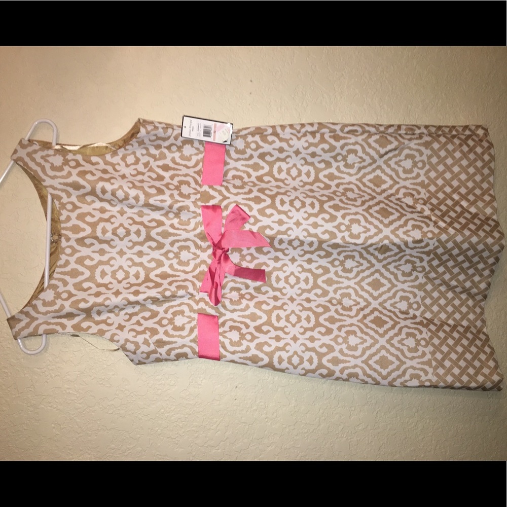 A white/ tan dress with pink bow tie in front.